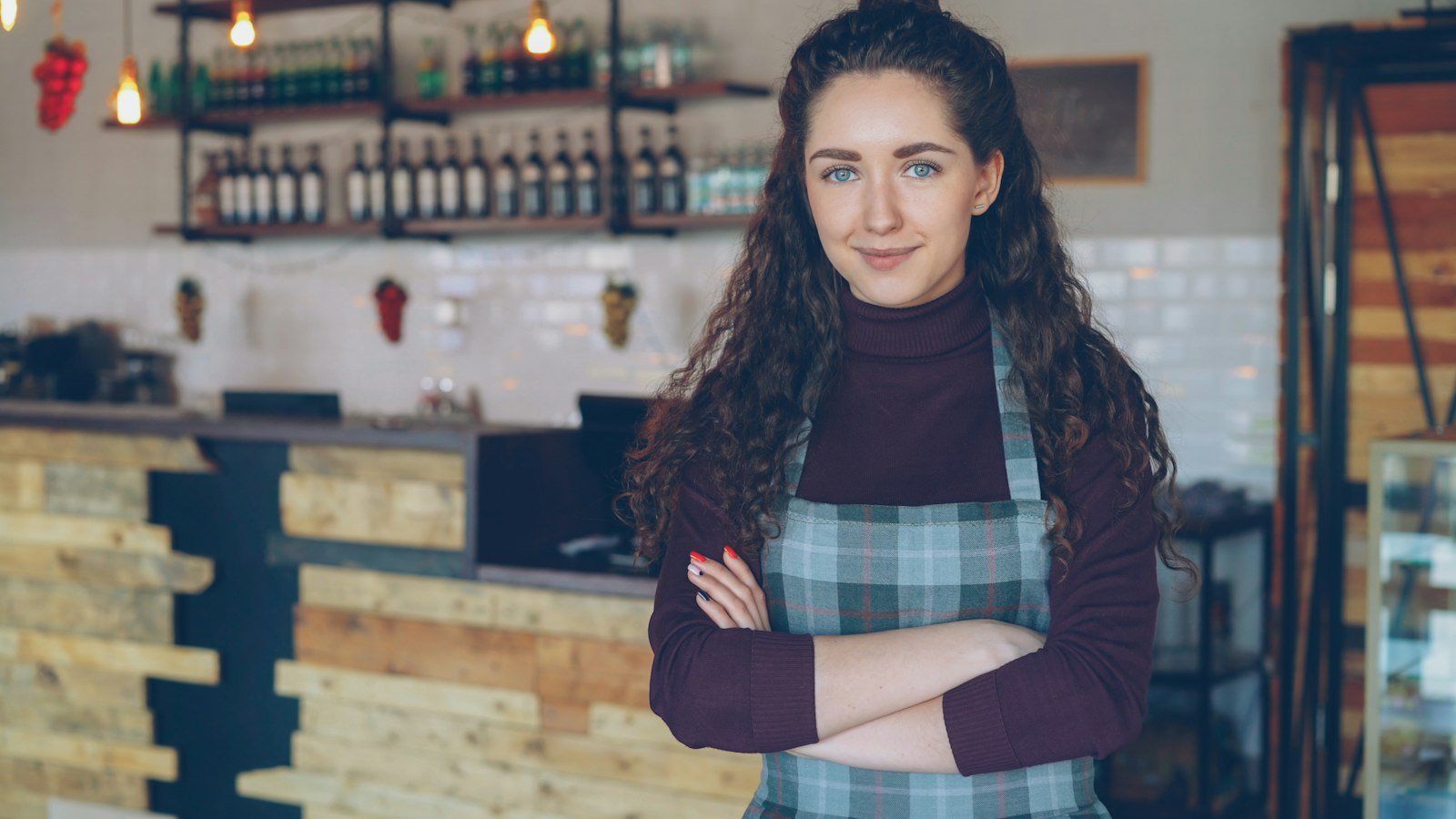 small coffee shop owner smiling behind her counter