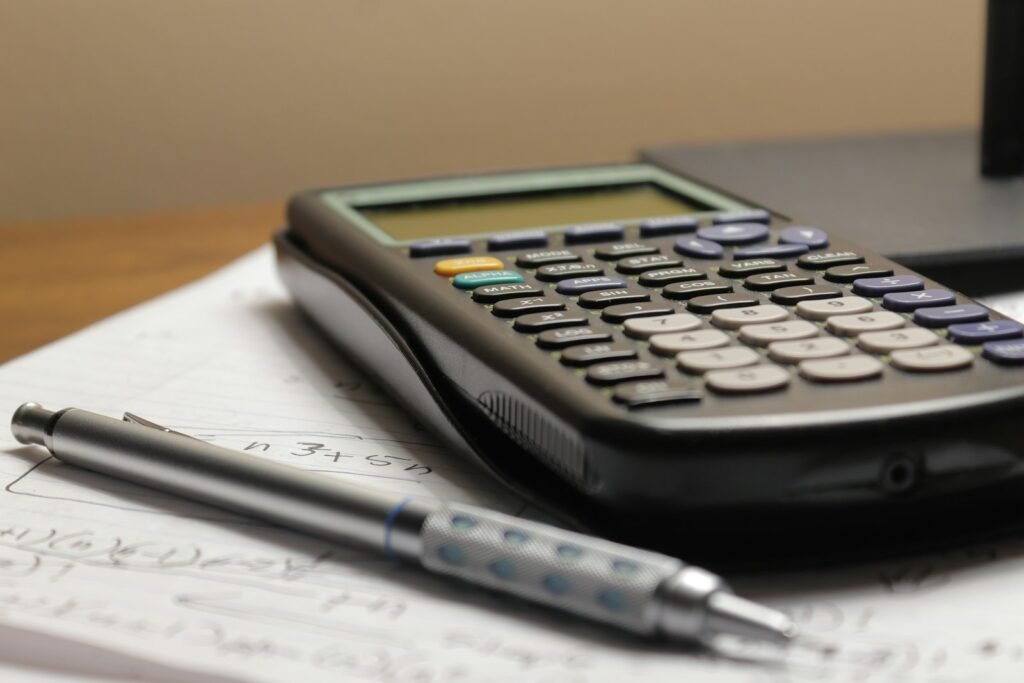 A calculator and a pen on top of a financial statement